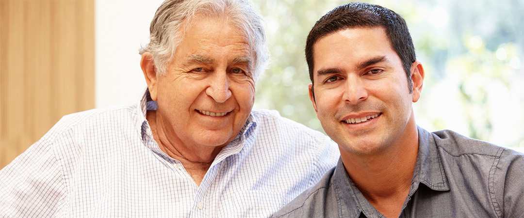 older man and a man smiling into camera