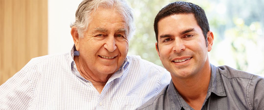 Senior man smiling next to younger man.